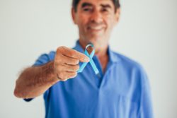 Man holding blue ribbon for prostate cancer awareness