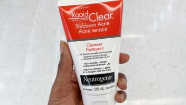 Close up of a hand holding a Neutrogena benzoyl peroxide product, representing the Neutrogena class action.