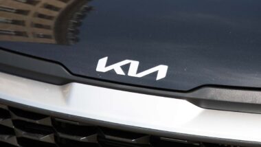 Close up of Kia emblem on a front bumper, representing the Kia class action.