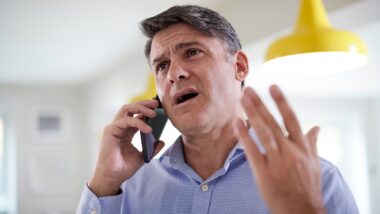 Frustrated Mature Man Receiving Debt Collection Call At Home