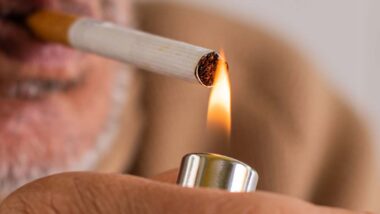 Close up of an elderly man lighting a cigarette, representing the tobacco company verdict.