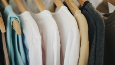 Close up of womens shirts hanging on a clothing rack.