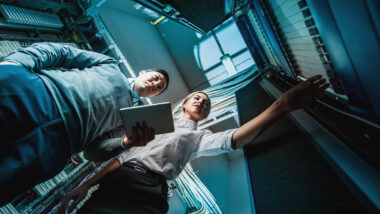 Engineers troubleshooting a problem in a server room, representing the health care data breach.