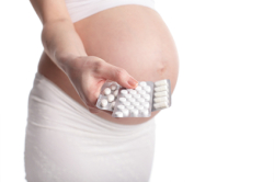 Pregnant woman holding pills