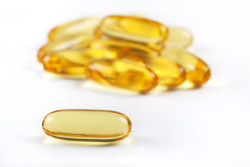 Close up of a cod liver fish oil capsule, a nutrional supplement high in omega-3 fatty acids, EPA, DHA, and high levels of vitamin A and vitamin D.