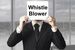 man holding whistleblower sign