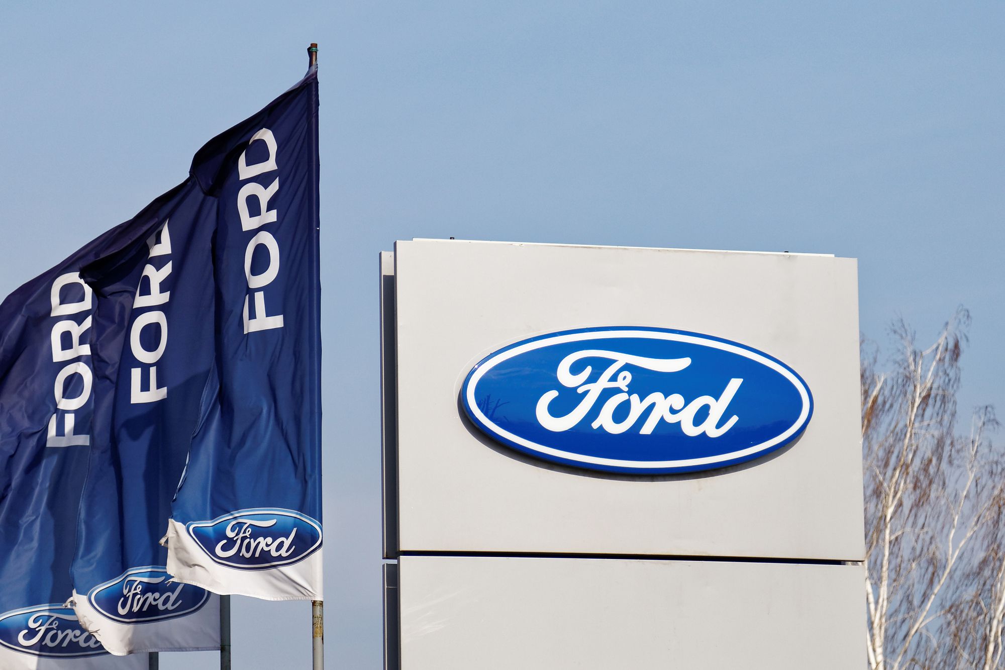 Ford sign and flags near Ford selling and service center.