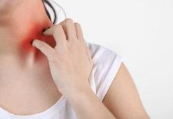 Allergies and sore throat concept. Woman scratching neck, closeup