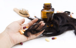 Close-up of a hand with pills and loss hair