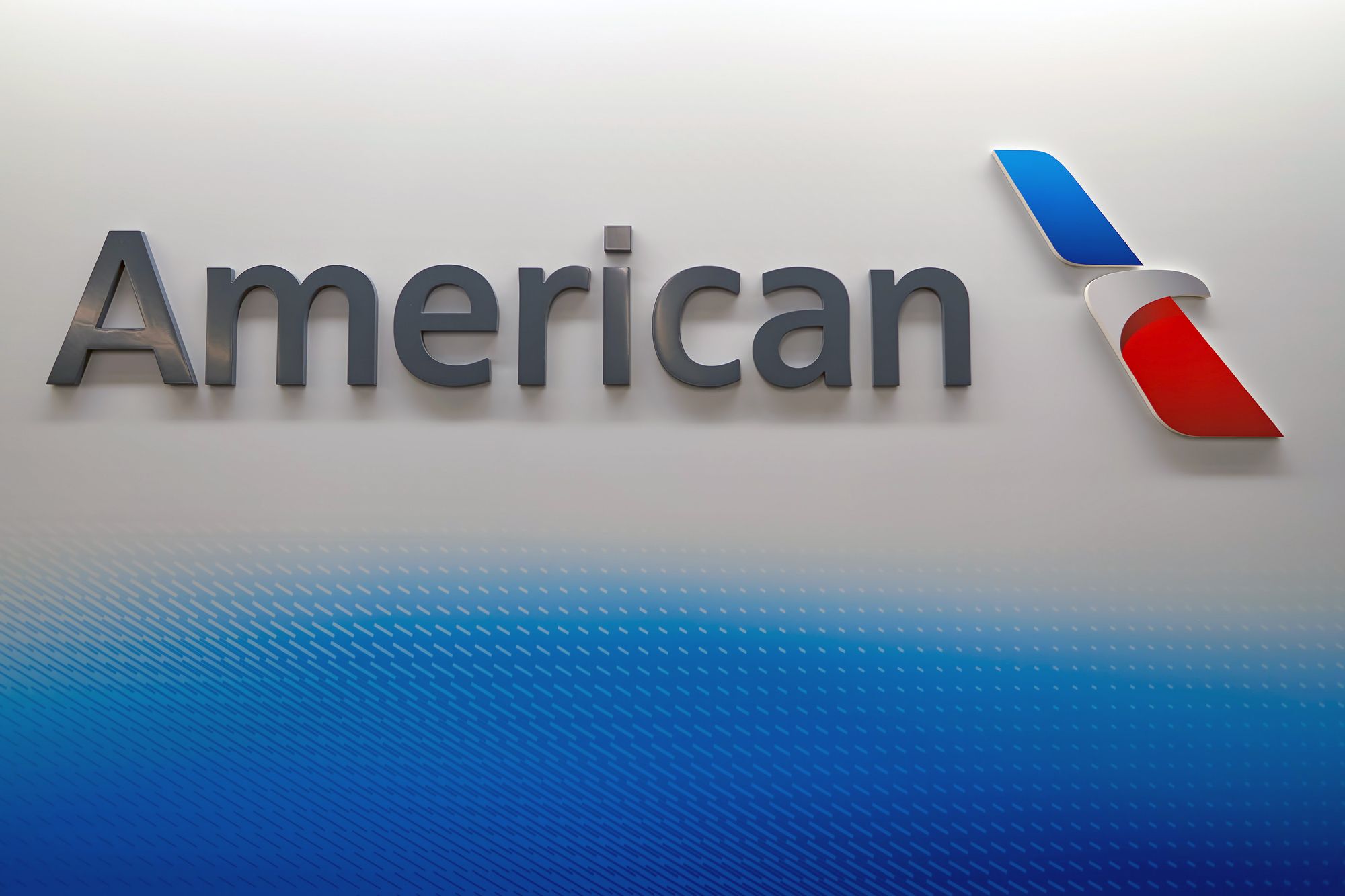 CHICAGO - MARCH 22, 2016: American Airlines logo on the wall at Chicago O'Hare International Airport. American Airlines, Inc. is a major American airline headquartered in Fort Worth, Texas.