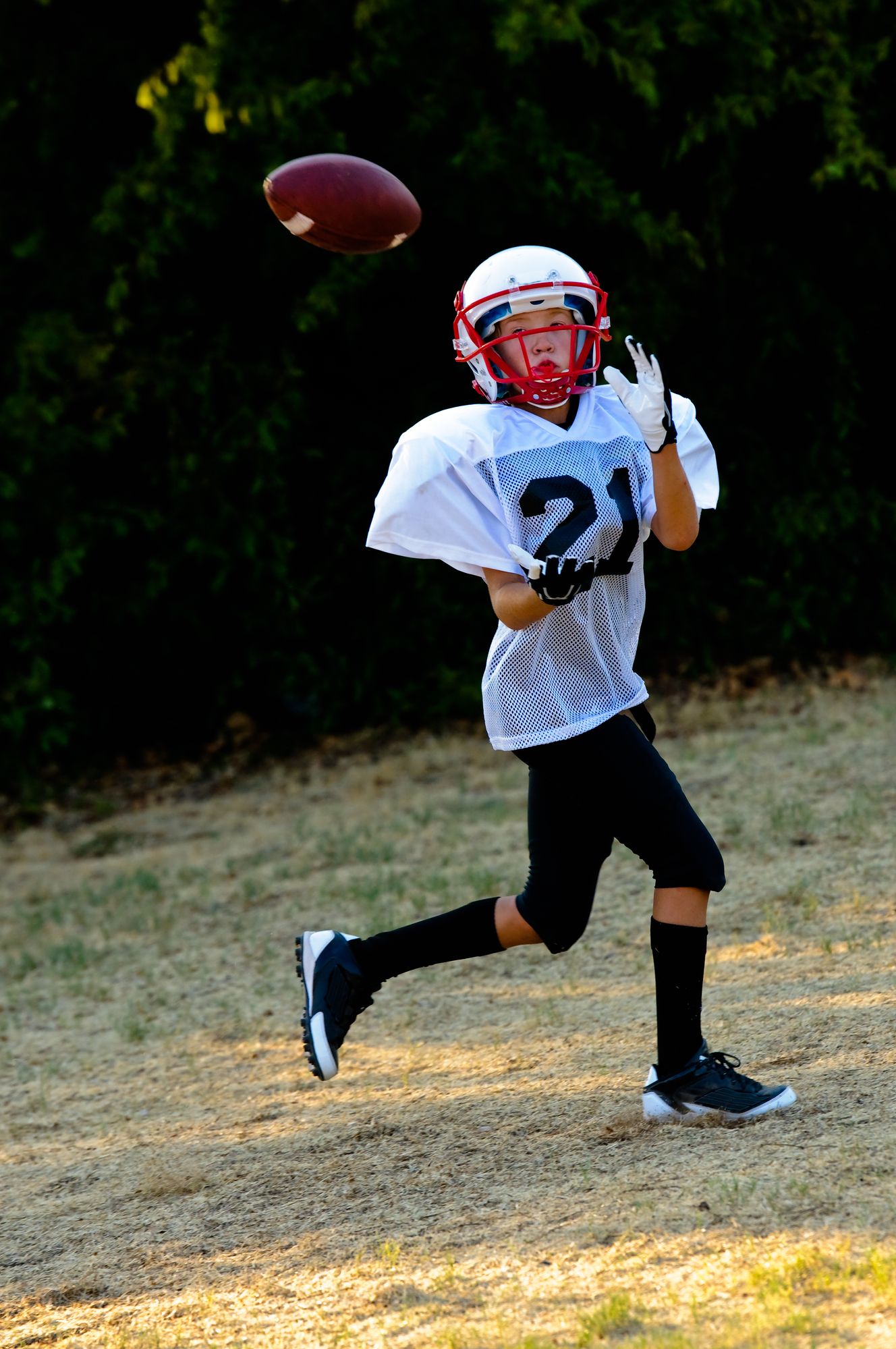 Young football player about to catch the football.