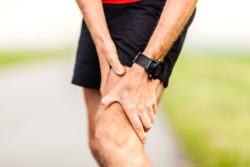 Runner holding sore leg, knee pain