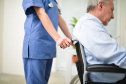 Nurse pushing a nursing home patient on a wheelchair