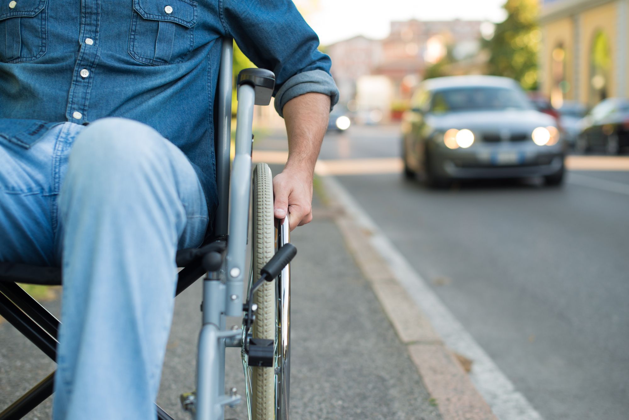 Detail of a man using a wheelchair in an urban street
