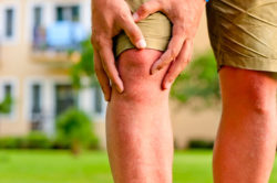 man holding sore knee