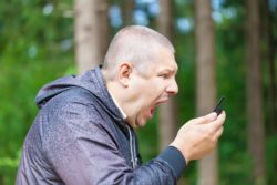 angry man dealing with cell phone robocalls