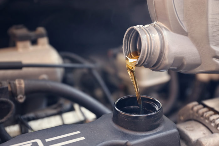 pouring new oil into car during Jiffy Lube oil change