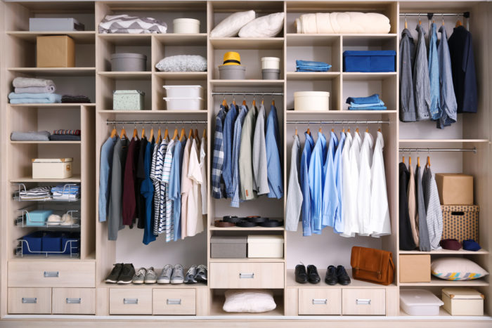 well organized closets by design wardrobe with lots of men's shirts, hats, shoes