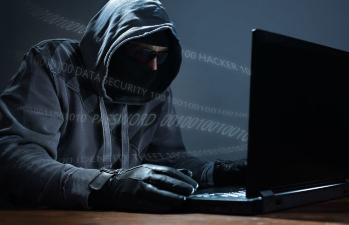 image of hacker breaking into computer to commit a data breach