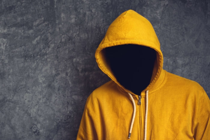 image showing faceless hacker in yellow hoodie
