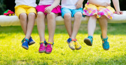 Children sitting and wearing colorful shoes