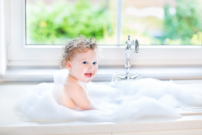 baby in sink getting a bath using aveeno baby wash