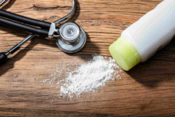 Baby powder on wooden table with stethoscope