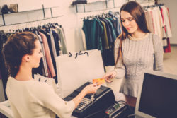A woman pays for clothes with a credit card.