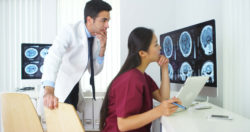 diverse doctor and medical technician viewing brain scans