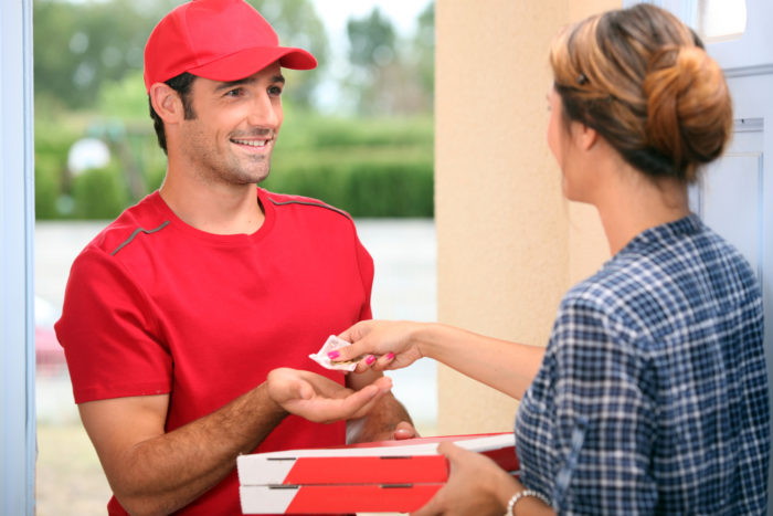 doordash pizza delivery driver handing pizza over to customer