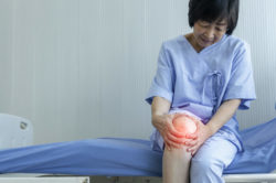 Elderly asian woman suffering knee pain in hospital
