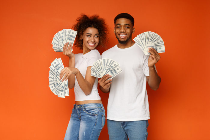man and woman holding a lot of cash money in their hands