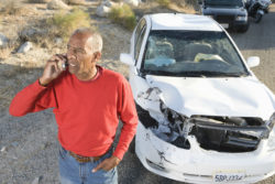 A man makes a phone call after a car crash.