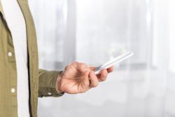 man using smartphone against light background