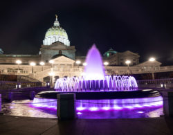 Lighting illuminates the fountain and Pennsylvania capitol.