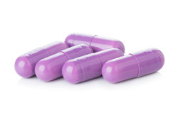 Purple medicine capsules on white background