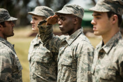 Uniformed military members salute.