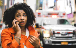 African American woman on phone after car accident