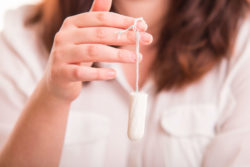 Woman with brown hair holding tampon