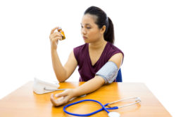 A woman monitors her blood pressure.