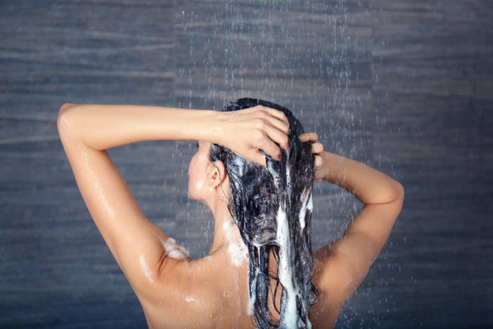 woman washing her hair with Sexy Hair shampoo in the shower
