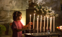 A boy lights a candle in church.