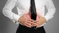 Businessman holding stomach in pain