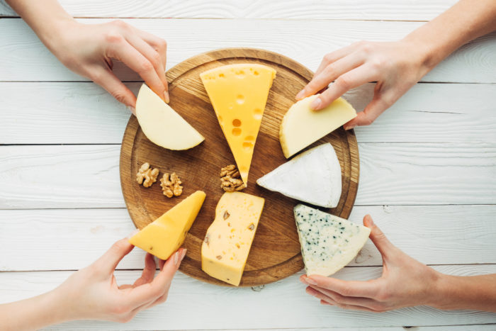 woman placing pieces of cheese on a plate