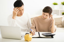 A concerned couple reviews banks statements