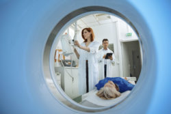 Two doctors prepare a patient for an MRI.