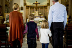 A family stands in the aisle of a church.