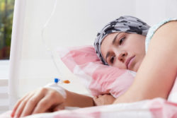 Girl with cancer lying on bed