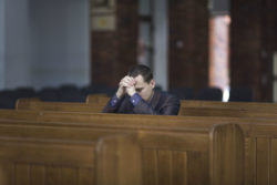 A man prays in a church.
