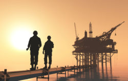 Oil workers walk near a platform.